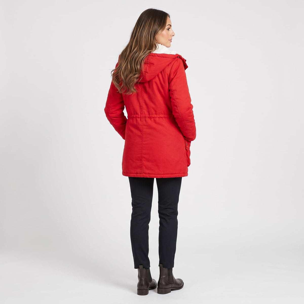 A woman wearing a red mid-length parka jacket with plush lining and an adjustable waist, shown from the back