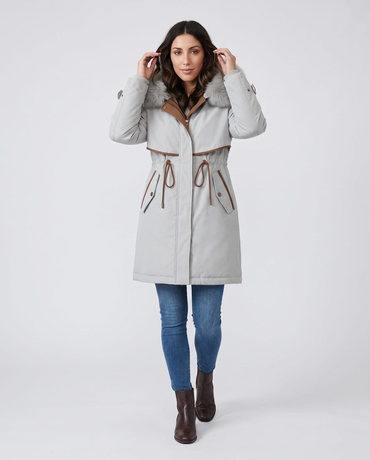 A woman wearing a white winter parka with a plush fur-trimmed hood, cozy lining, and adjustable waist