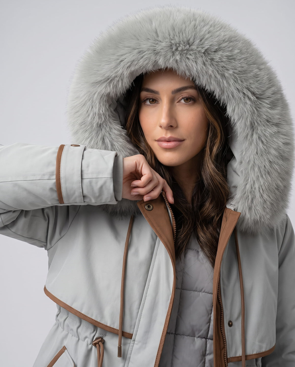 Close-up of a woman wearing a light gray winter parka, showing the large plush fur-trimmed hood