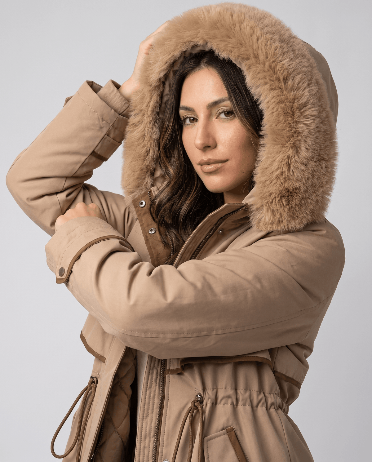 Close-up of a woman wearing a beige winter parka, showing the plush fur-trimmed hood and cozy lining