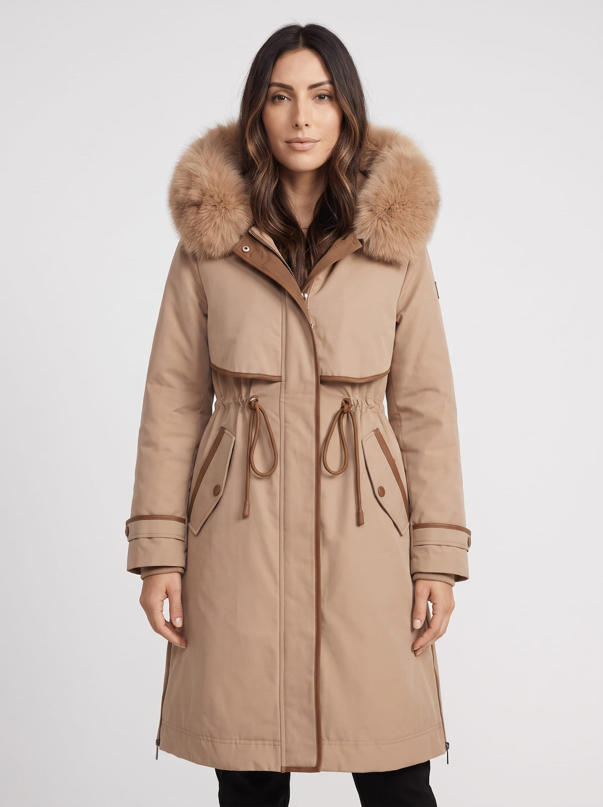 Beige plush hood trim winter parka with belted waist and front pockets worn by a female model