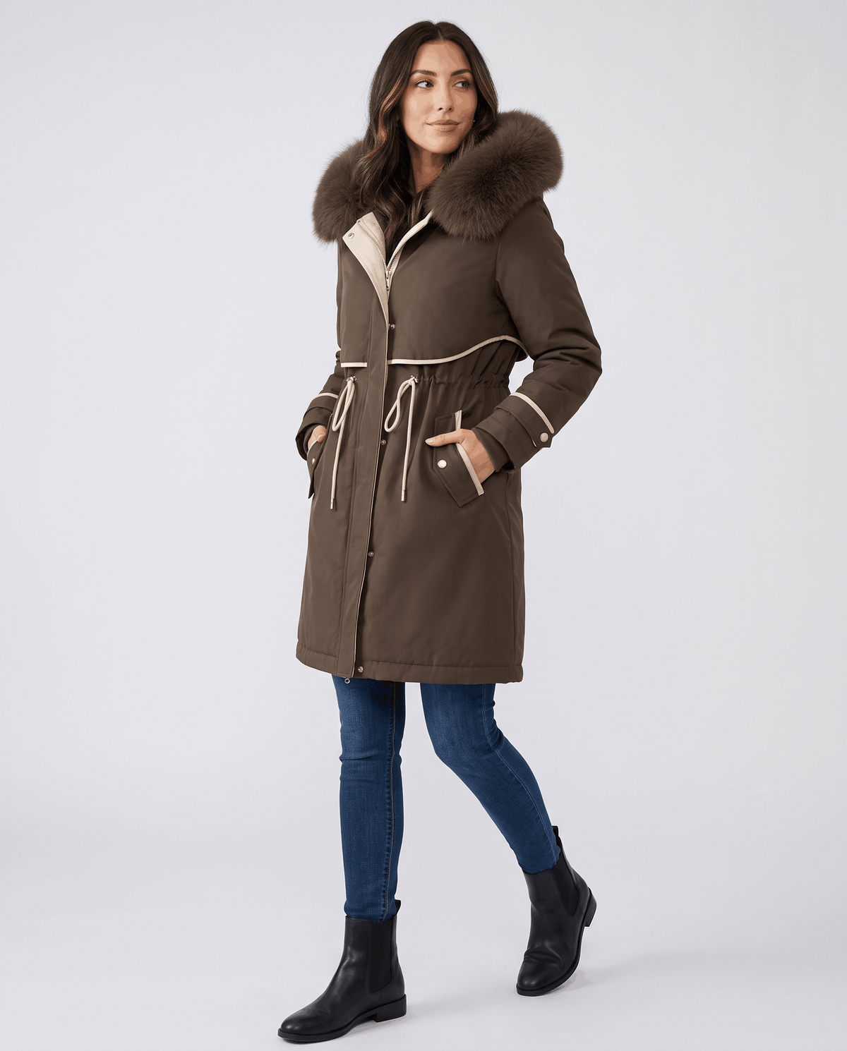 A woman wearing a brown winter parka with a plush fur-trimmed hood, cozy lining, and adjustable waist