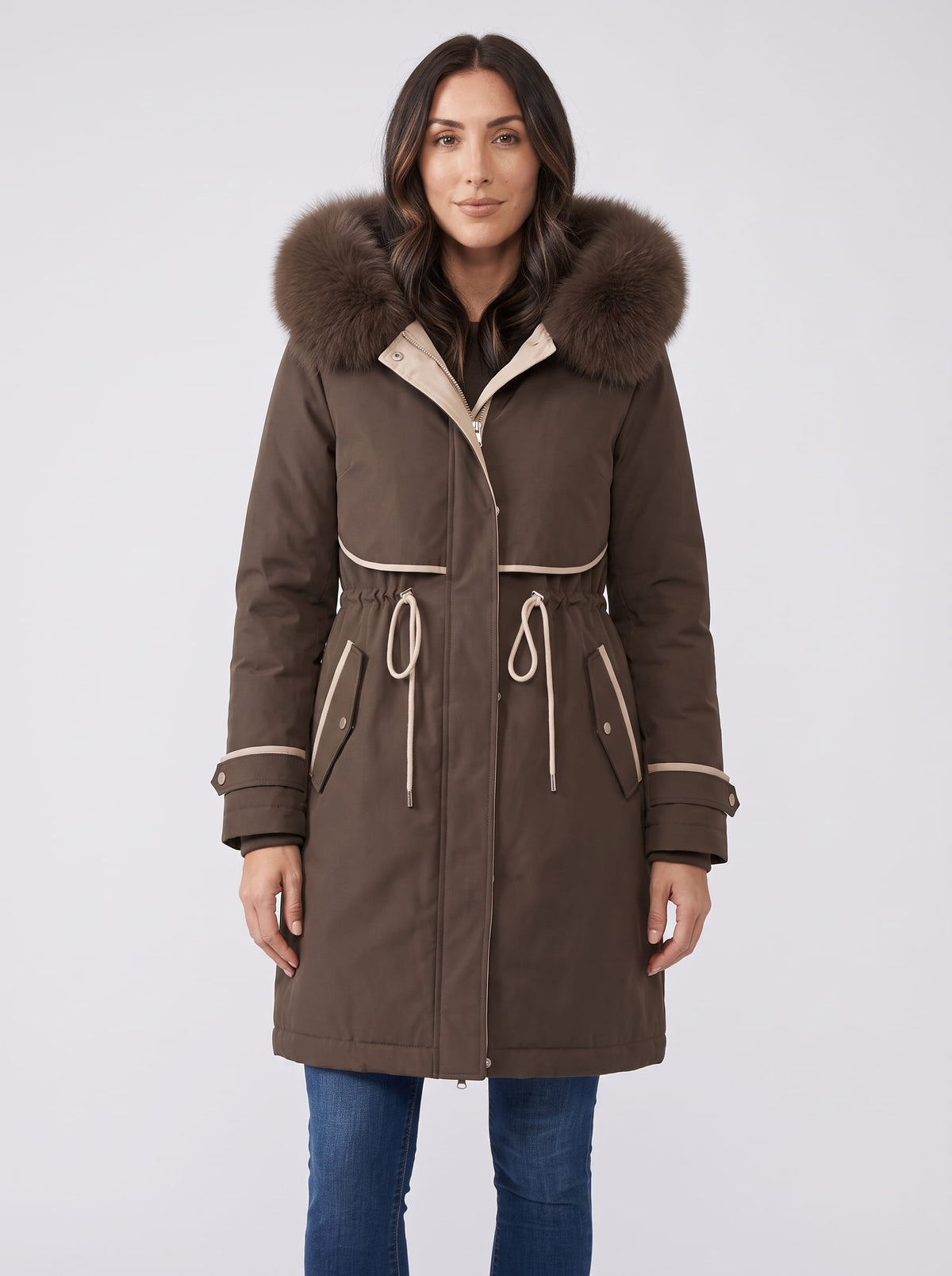 Brown plush hood trim winter parka with belted waist and front pockets worn by a female model