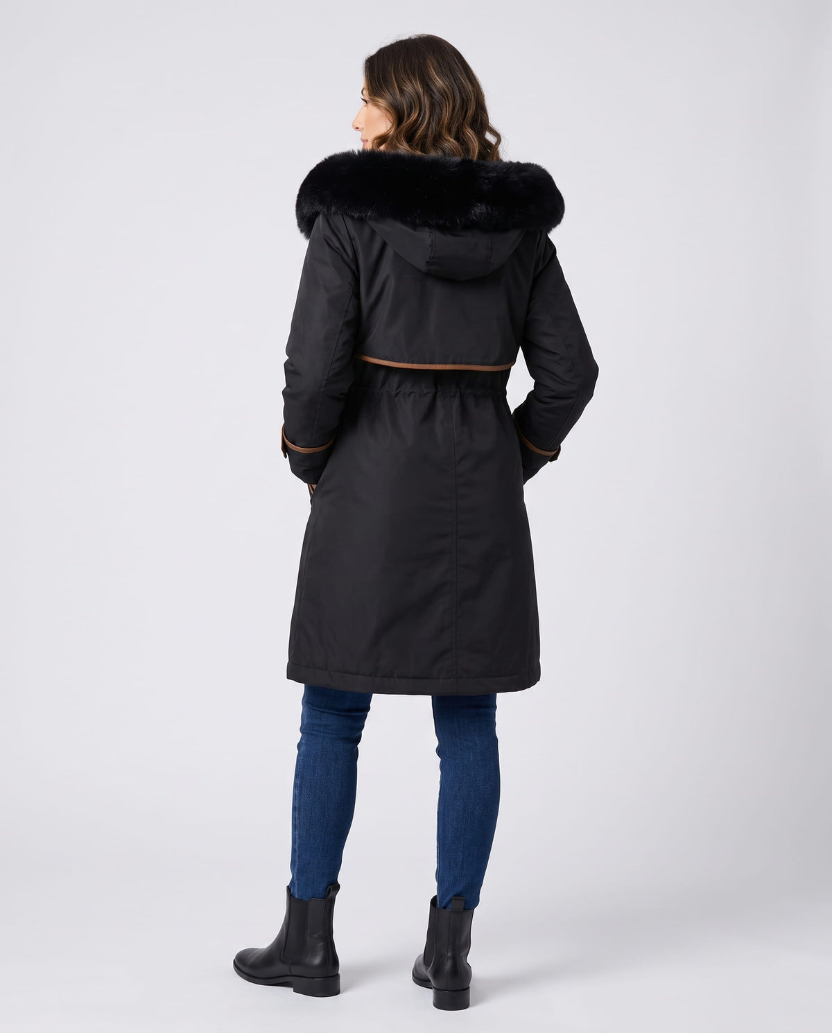 Close-up of a woman wearing a black winter parka, showing the plush fur-trimmed hood and cozy lining