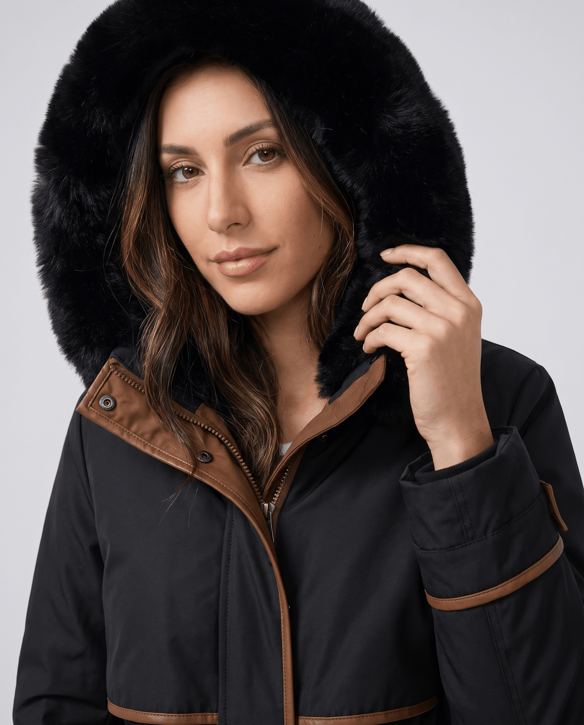 Close-up of a woman wearing a black winter parka, showing the plush fur-trimmed hood and cozy lining