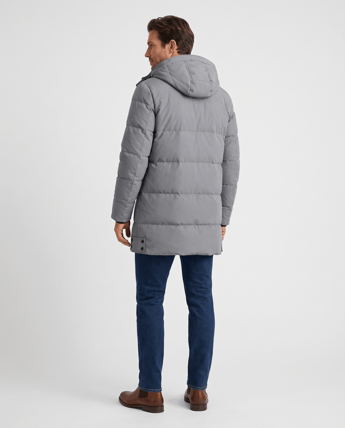 A man wearing a gray longline puffer parka jacket with a hood, shown from the back