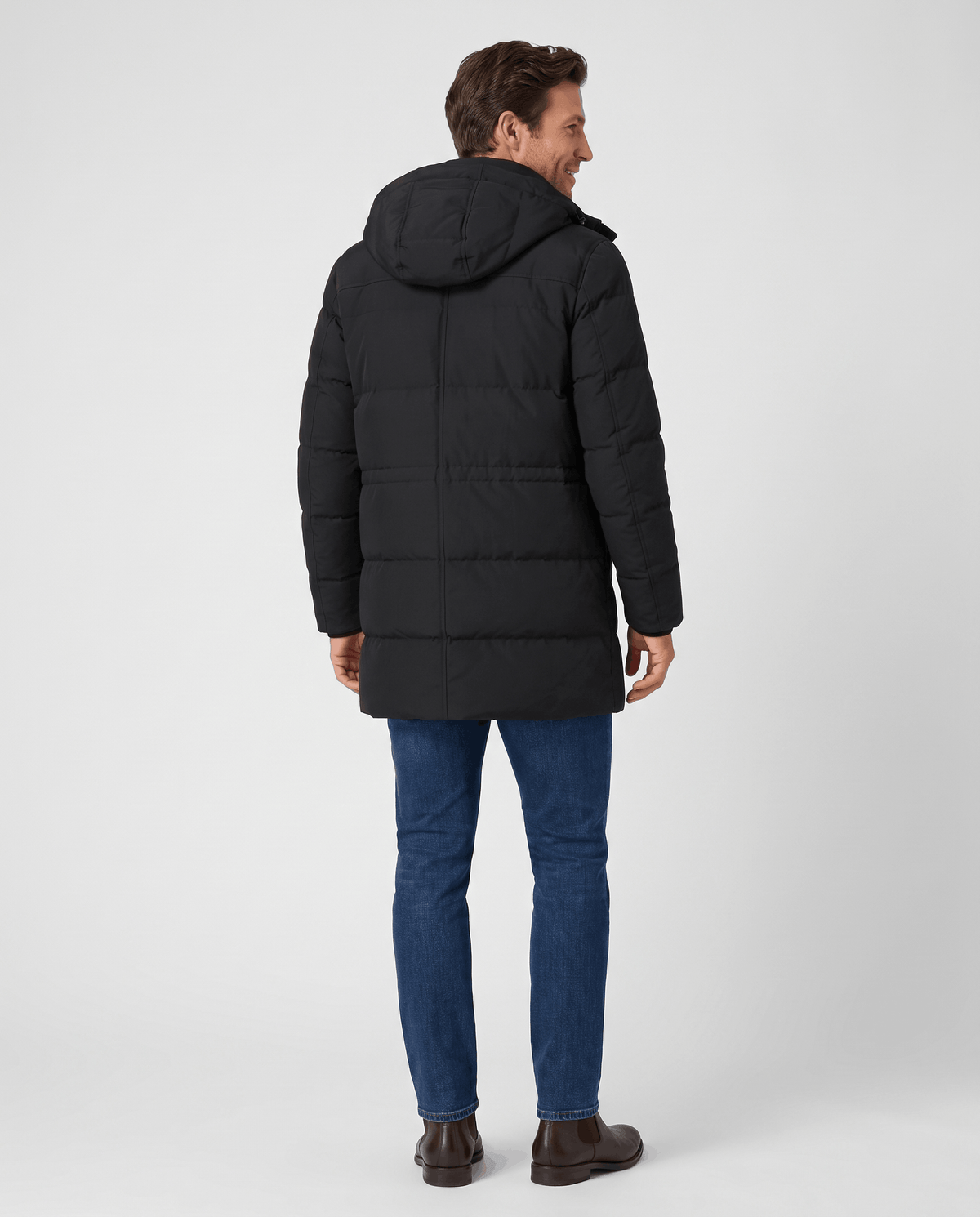 A man wearing a black hooded puffer parka jacket with a longline fit, shown from the back