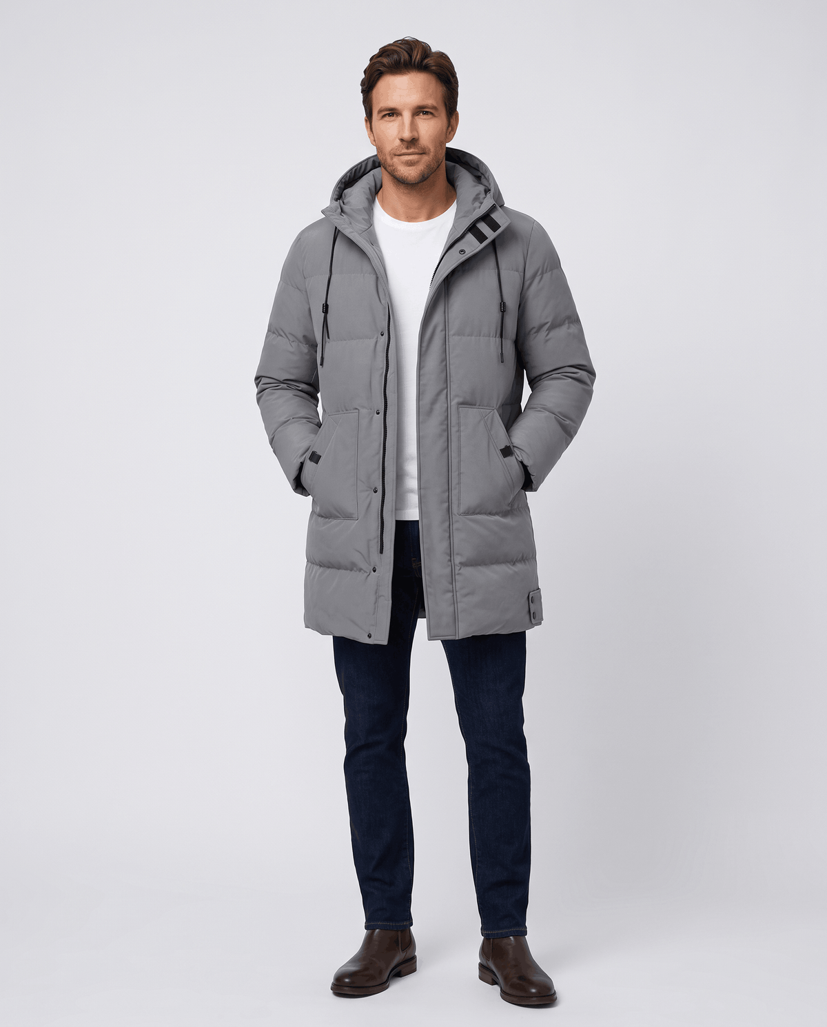 A man wearing a gray puffer parka jacket with a hood, longline fit, and layered winter design