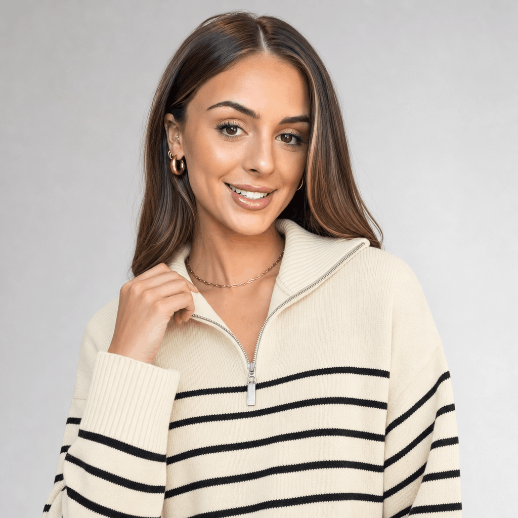 Close-up of the female model wearing the cream striped sweater, highlighting the quarter zipper, raised collar, and thin black stripe pattern.