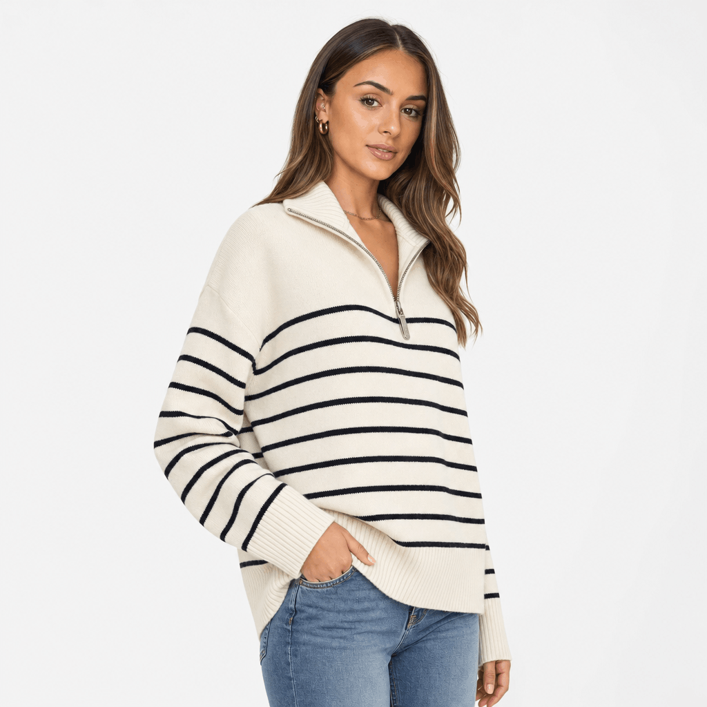 Female model wearing the cream and black striped quarter-zip sweater with blue jeans.