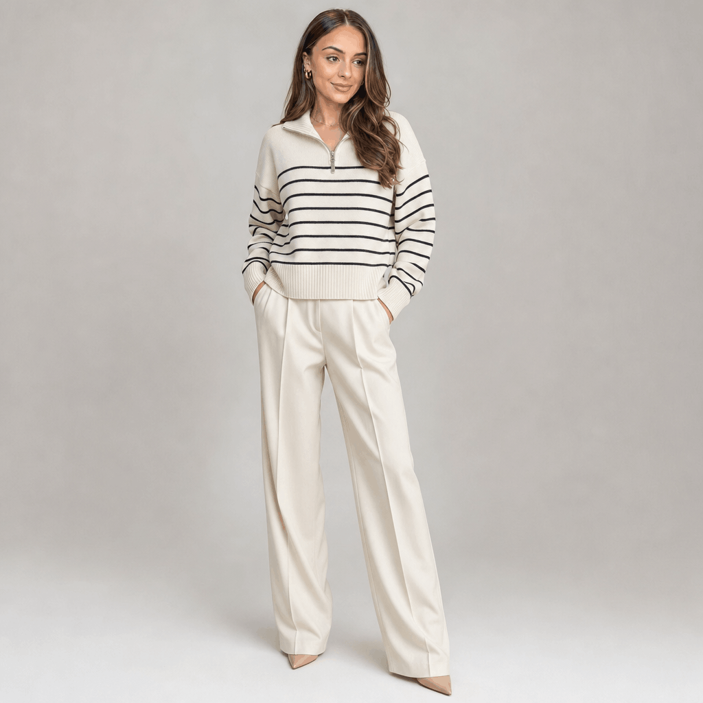 Full-body view of a female model wearing the cream striped quarter-zip sweater with light-colored wide-leg trousers.