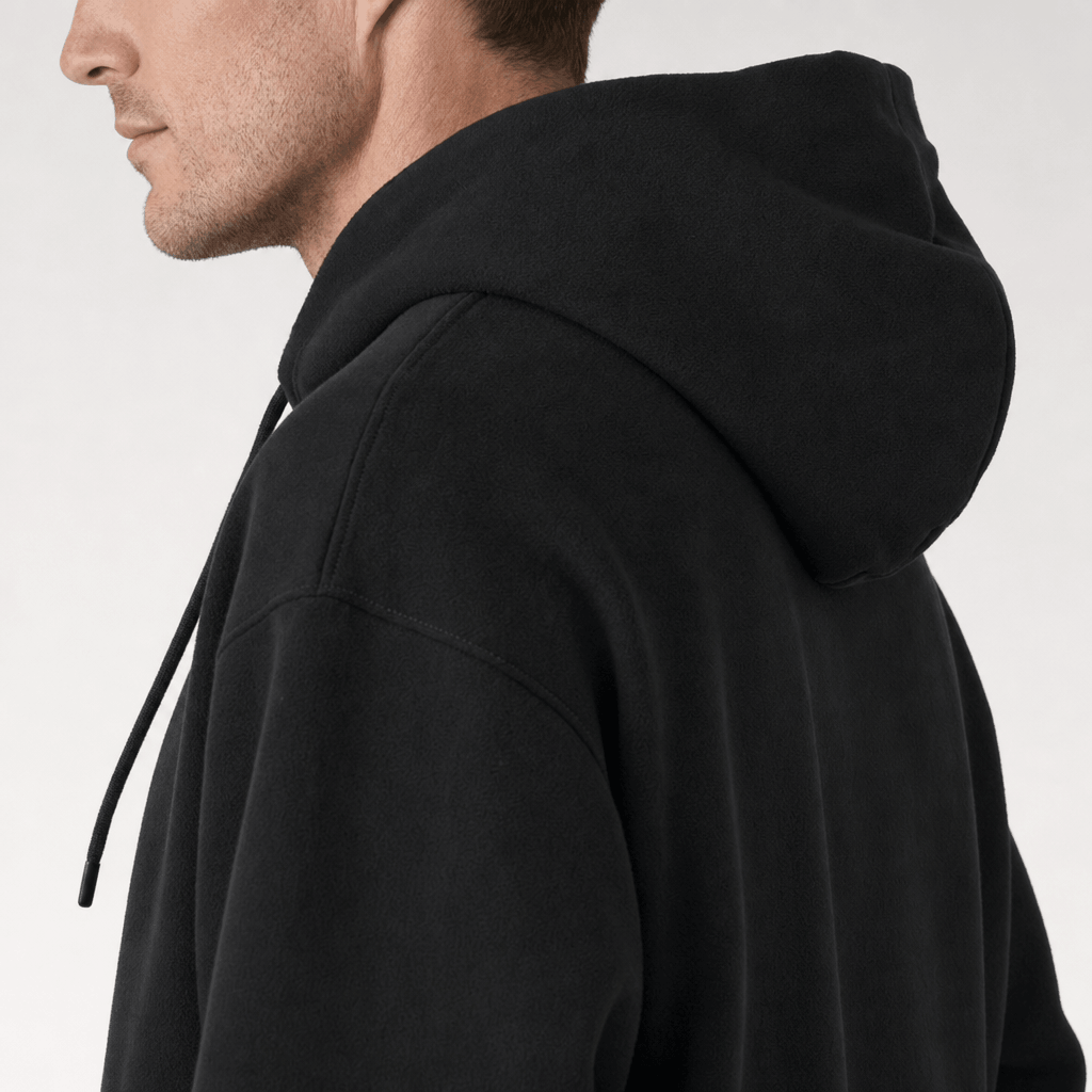 Close-up side view of a black pullover hoodie, highlighting the hood and drawstring.