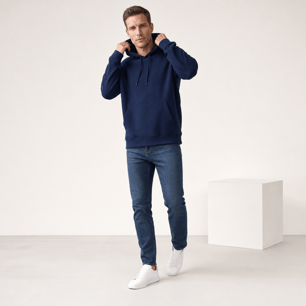 Male model wearing the navy blue pullover hoodie while adjusting the hood.