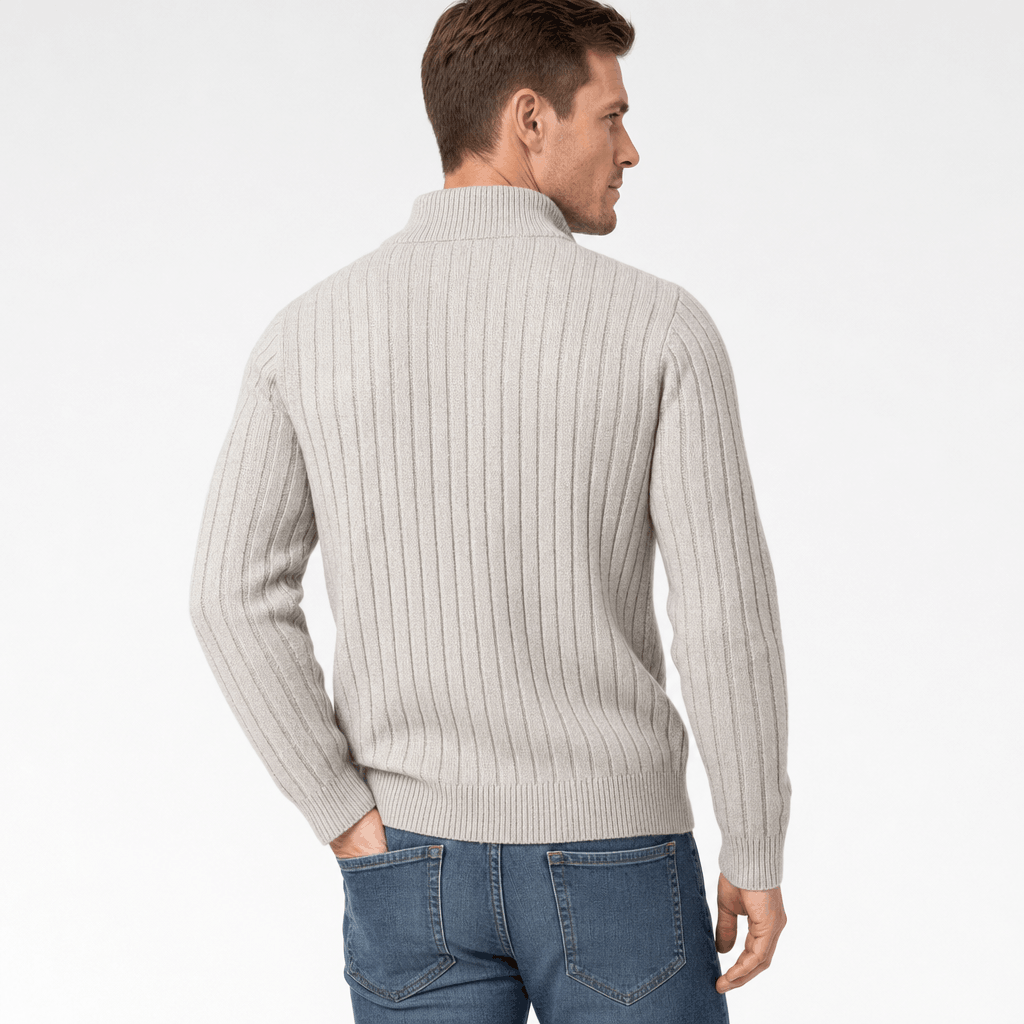 Back view of the man wearing the ivory ribbed half-zip sweater with blue jeans.