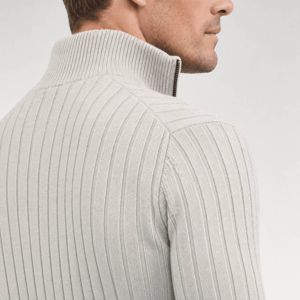 Side close-up showing the raised collar, shoulder, and ribbed texture of the ivory sweater.