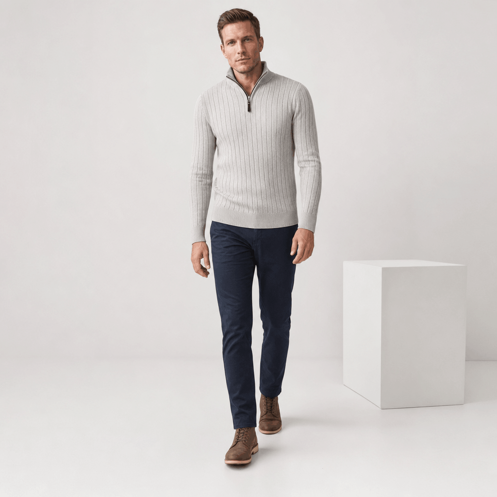 Full-body view of the man wearing the ivory ribbed half-zip sweater with dark pants.