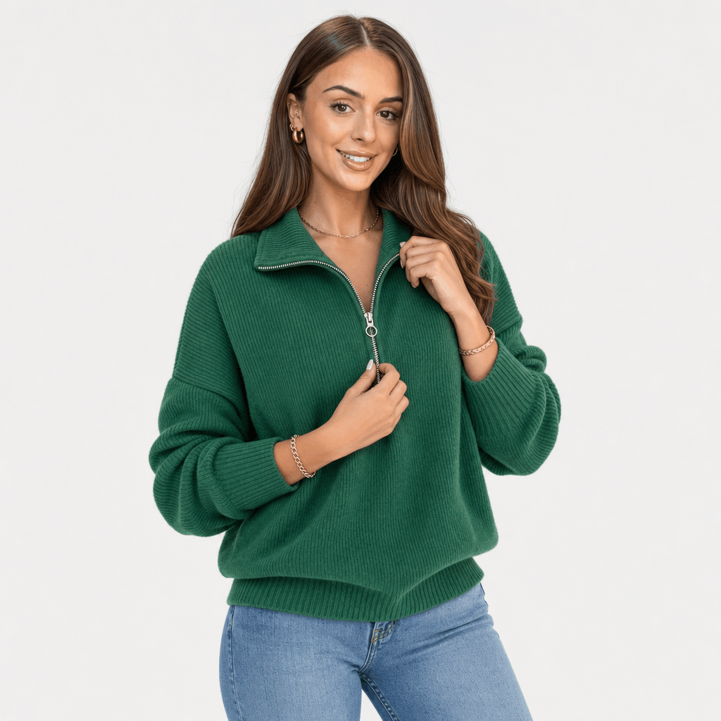 Woman wearing a forest green ribbed half-zip sweater with blue jeans, shown in a relaxed pose.
