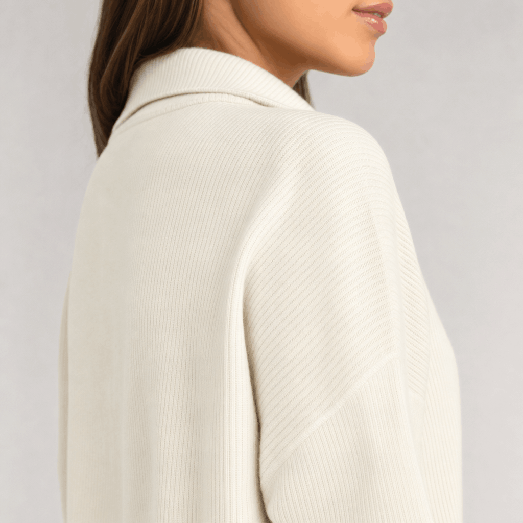 Side close-up showing the ribbed knit texture of the cream sweater.
