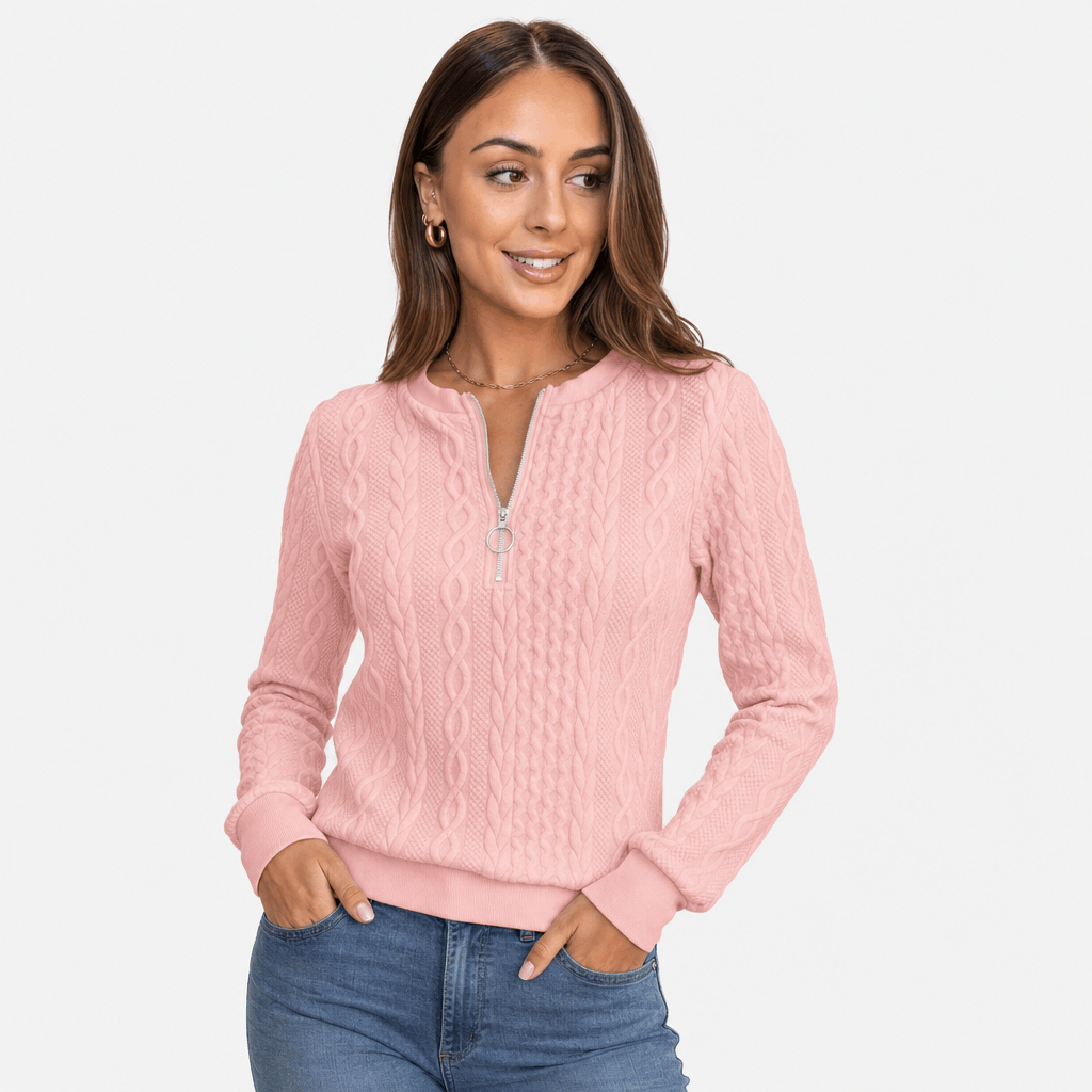 Woman wearing the soft pink ribbed half-zip sweater with blue jeans, shown in a relaxed standing pose.