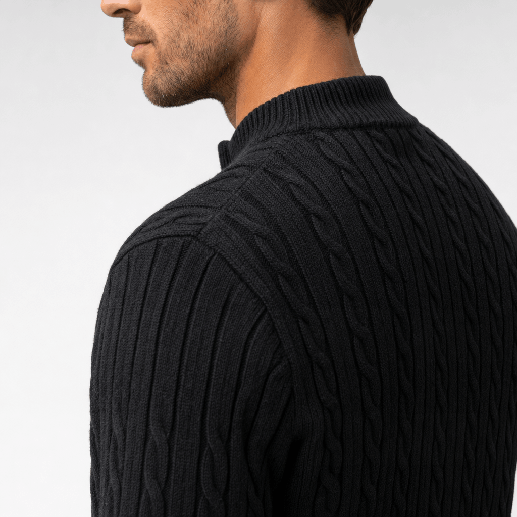 Black cable knit quarter zip sweater with a structured funnel collar and ribbed detailing on a man.