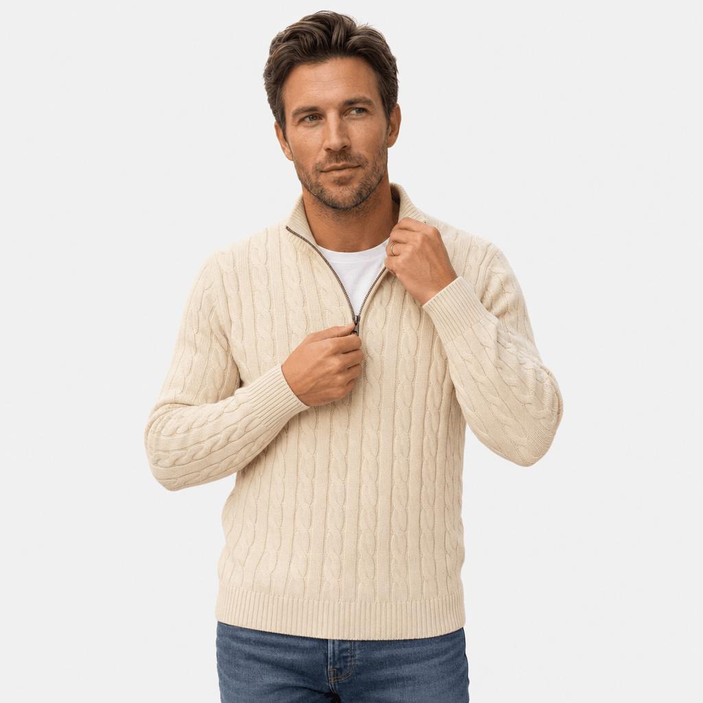 Cream cable knit quarter-zip sweater with a funnel collar, ribbed cuffs, and hem worn over a white t-shirt.