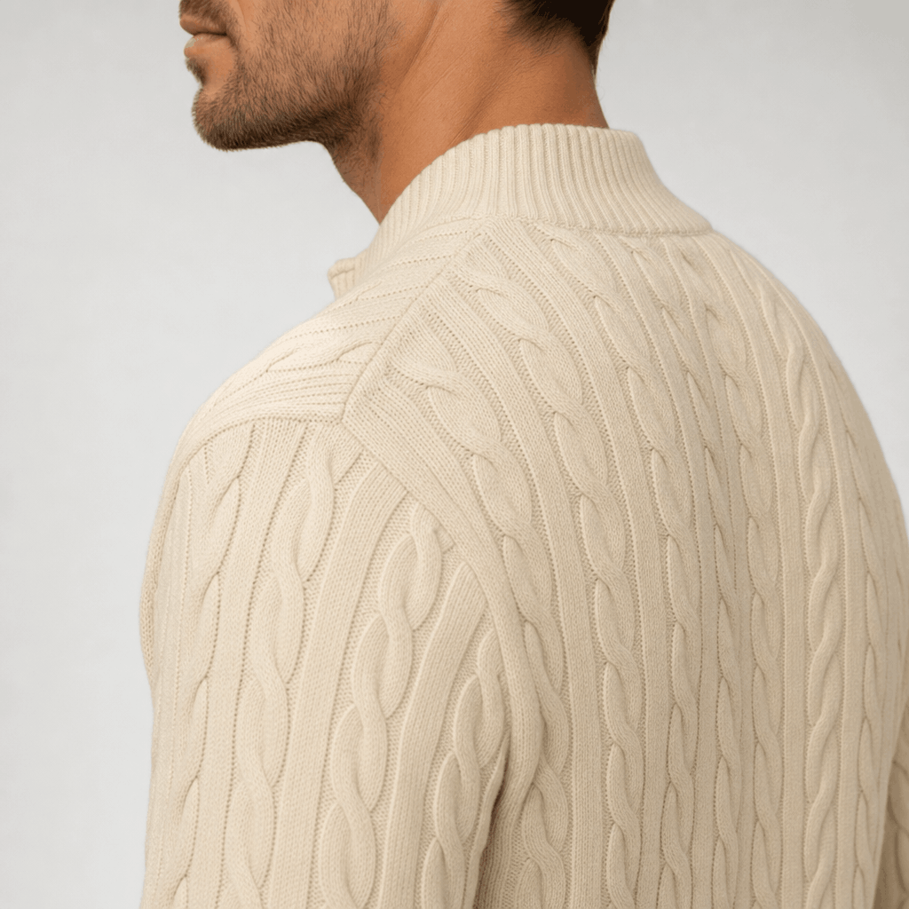Cream cable knit quarter zip sweater with a structured funnel collar and ribbed trim on a man.
