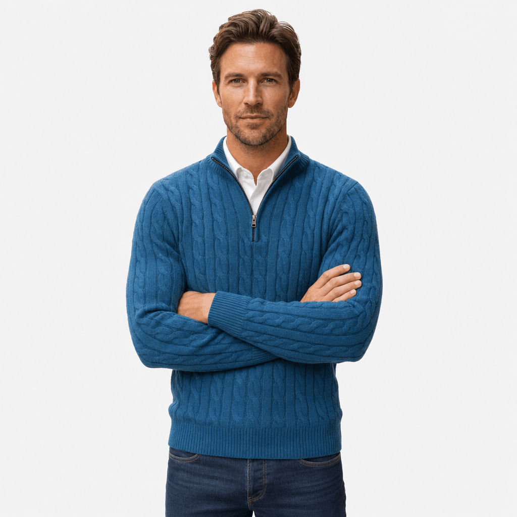 Blue cable knit quarter-zip sweater with a funnel collar, ribbed cuffs, and hem, worn over a white collared shirt.
