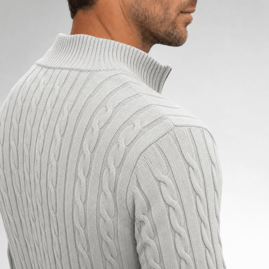 Light grey cable knit quarter zip sweater with a structured funnel collar and vertical twisted cable panels.