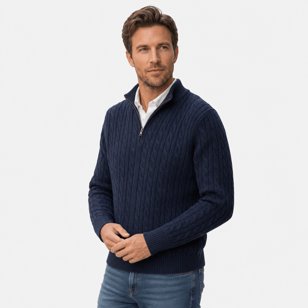 Navy blue cable knit quarter zip sweater with a funnel collar, ribbed cuffs, and hem worn over a white collared shirt.