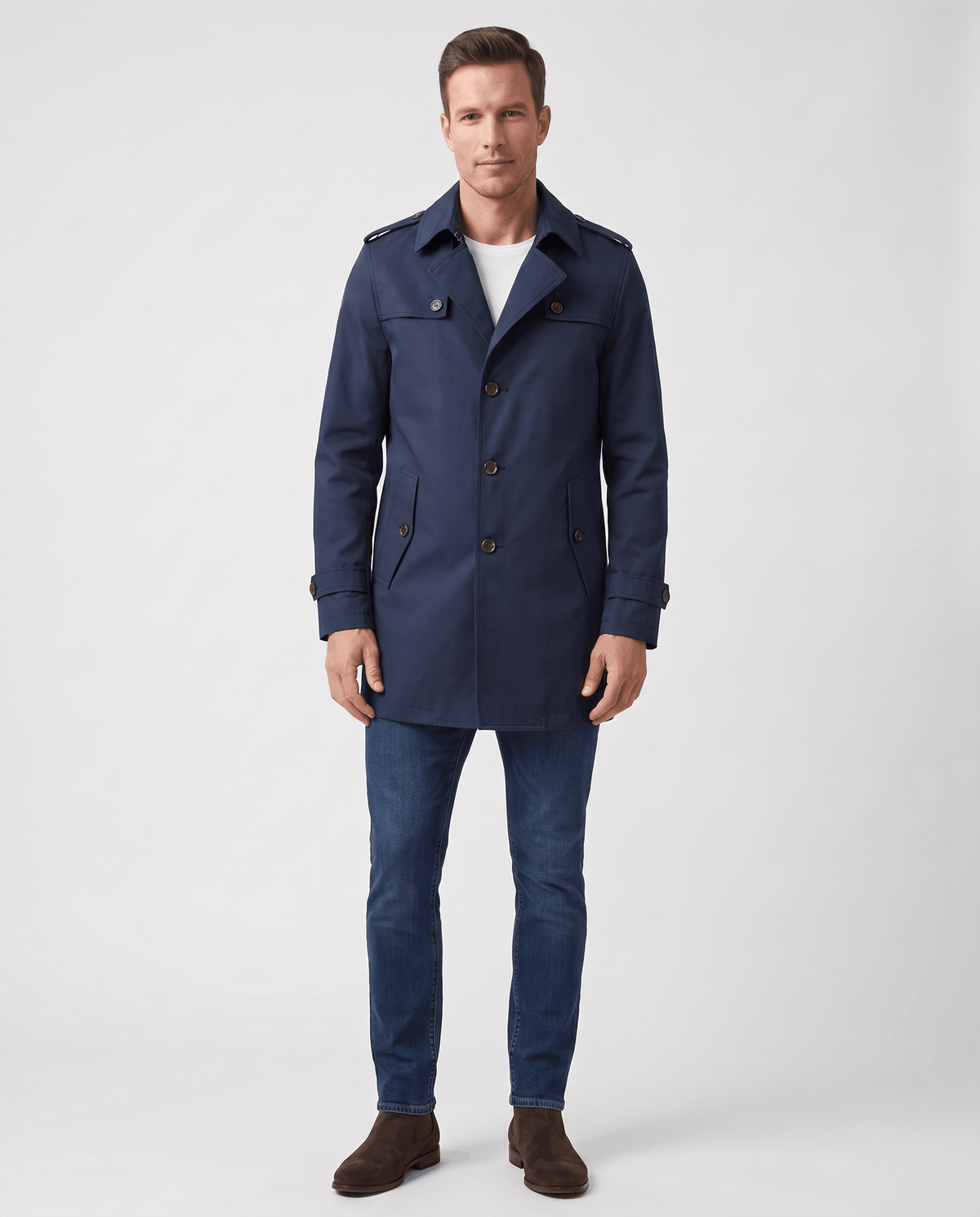 A man wearing a navy blue single-breasted trench coat with a mid-length fit, structured lapels, and tailored silhouette