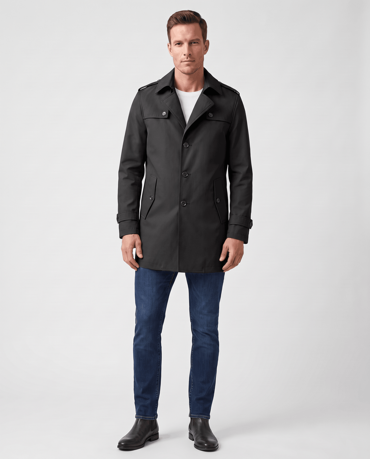 A man wearing a black single-breasted trench coat with a mid-length fit, structured lapels, and tailored silhouette