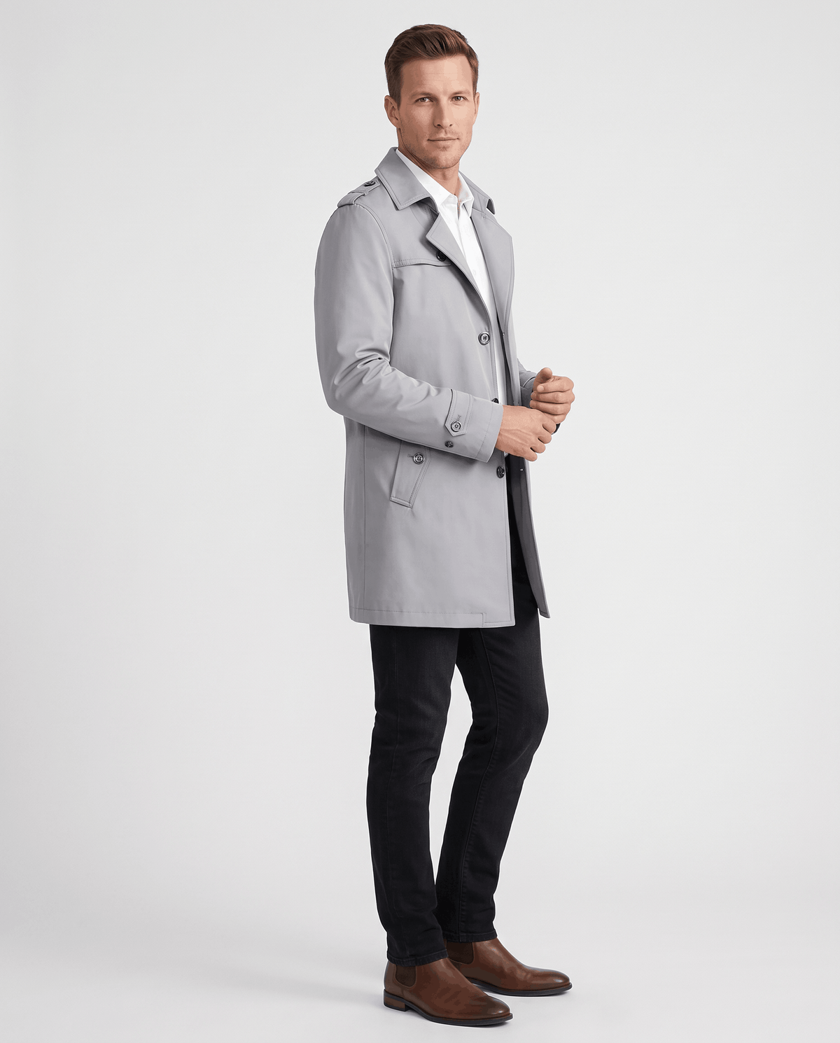 A man wearing a light gray single-breasted trench coat with structured lapels and tailored fit, side view