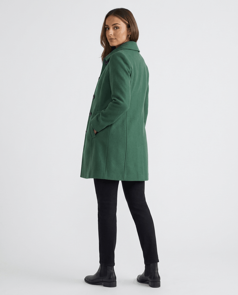A woman wearing a green single-breasted mid-length trench coat, shown from the back