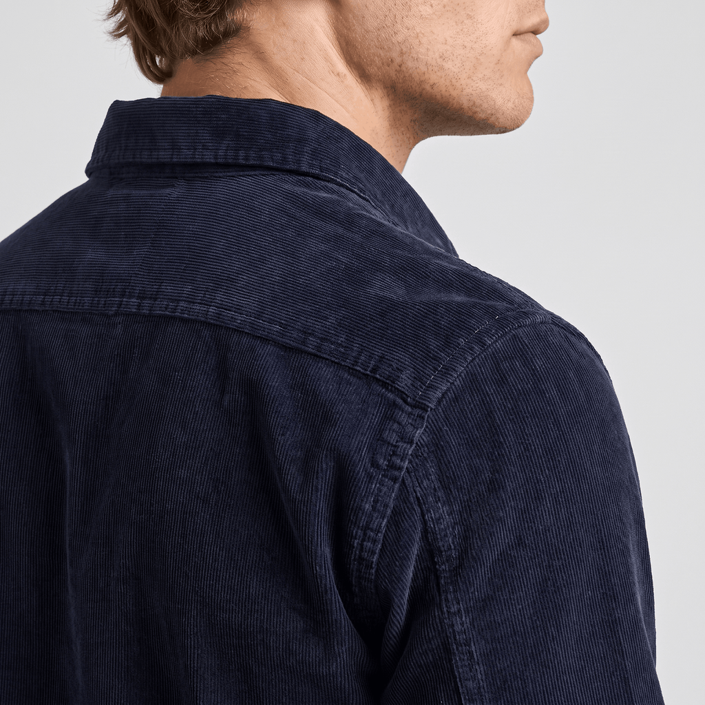 Navy blue corduroy shirt with fine ribbing, featuring a structured spread collar and clean regular fit shoulder seams.