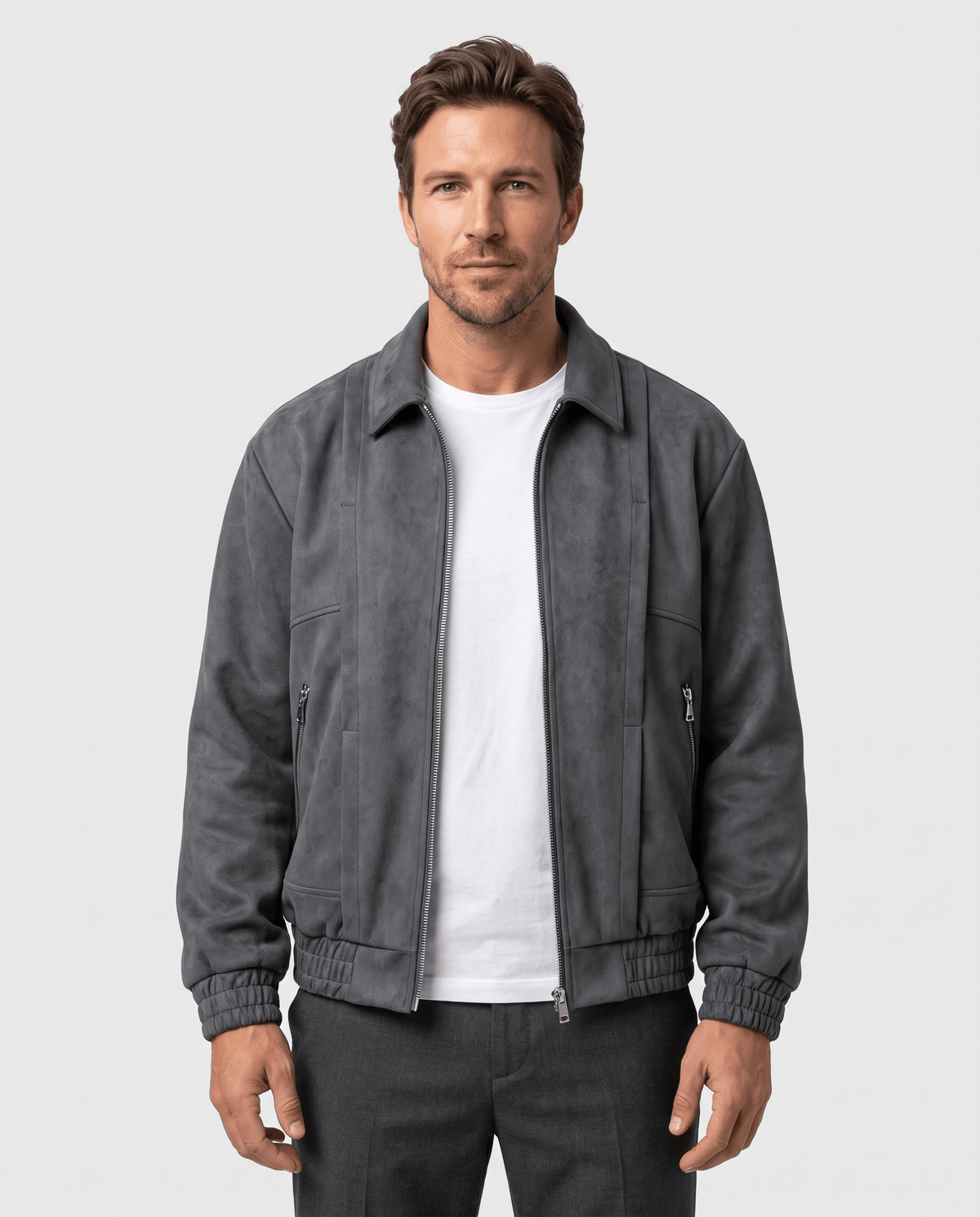 A man wearing a dark gray suede bomber jacket with a relaxed fit, shown from the front