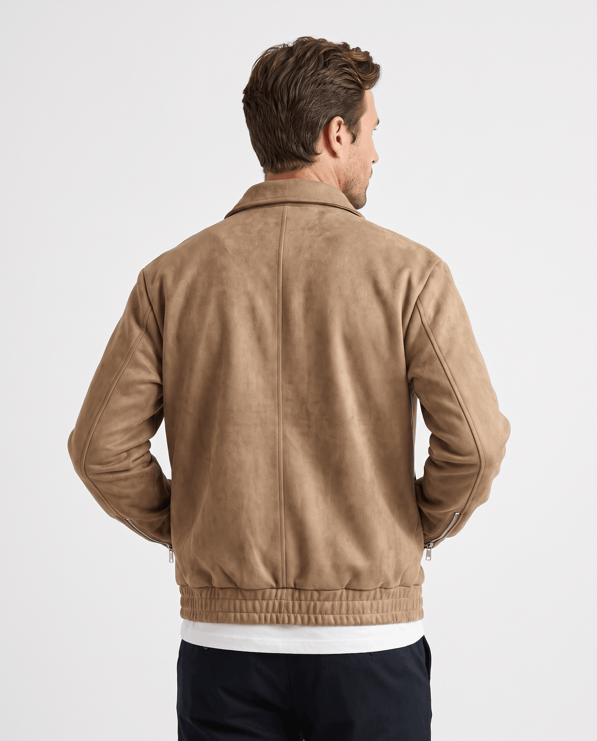A man wearing a brown suede bomber jacket with a relaxed fit and zip pockets, shown from the back