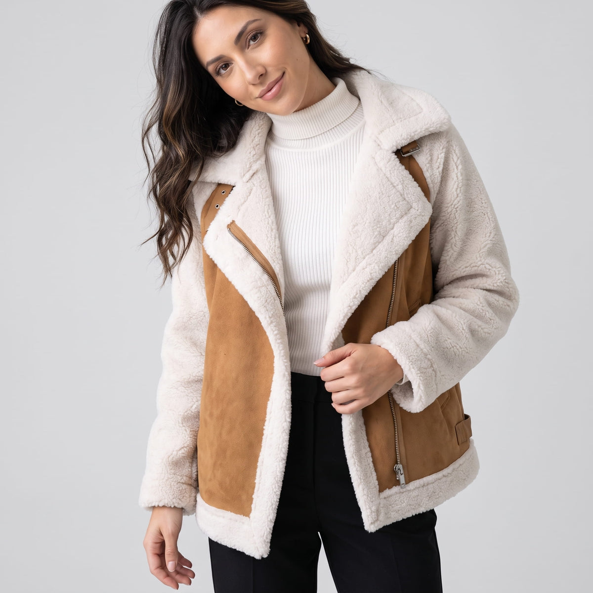 Close-up of a beige suede leather shearling aviator jacket showing the oversized sherpa collar and plush trim