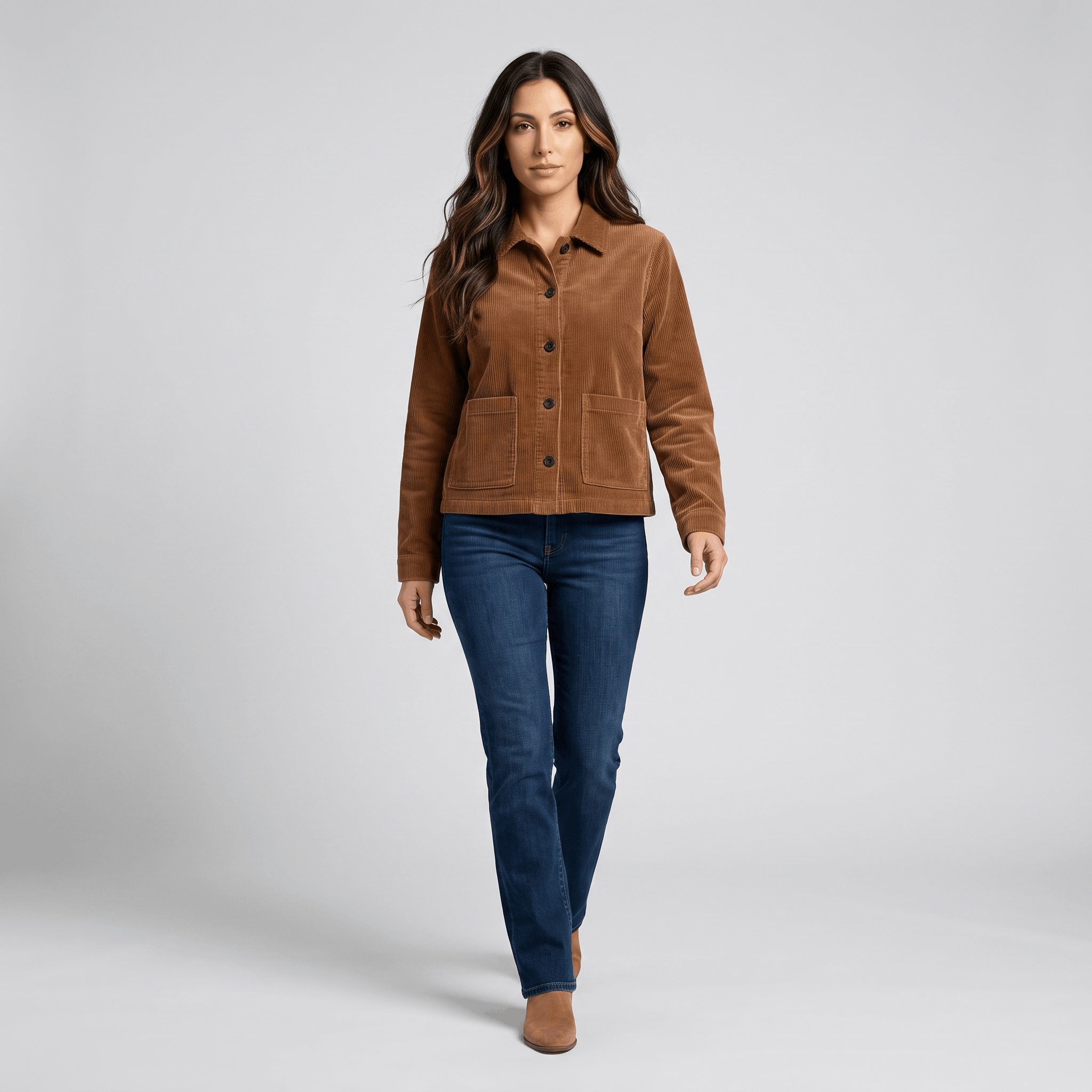 Brown cotton corduroy chore jacket with a boxy fit, button-front, and deep patch pockets worn with dark blue jeans.