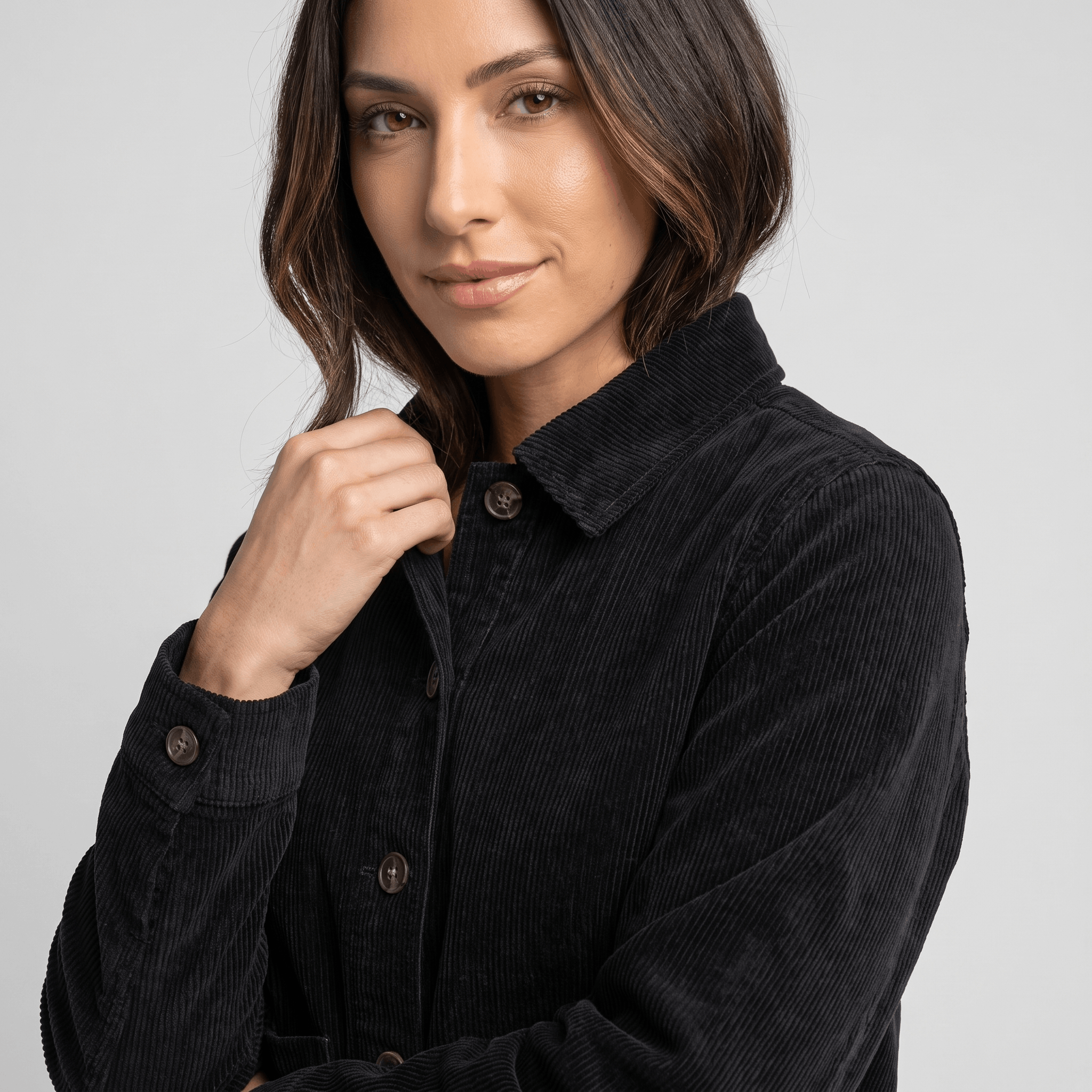 Black cotton corduroy chore jacket with a boxy fit, button-front closure, and textured wide wale fabric.