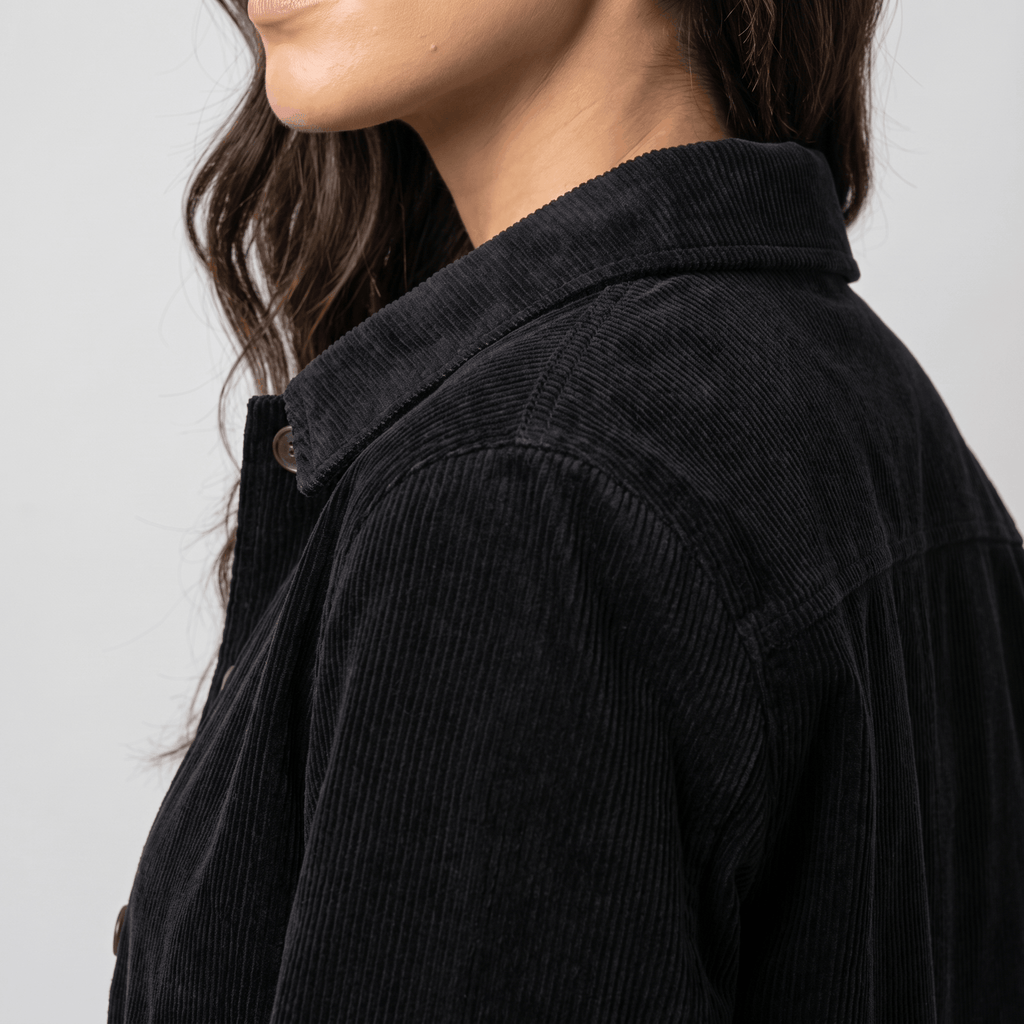 Black wide-wale cotton corduroy chore jacket with a structured collar and button-front closure.
