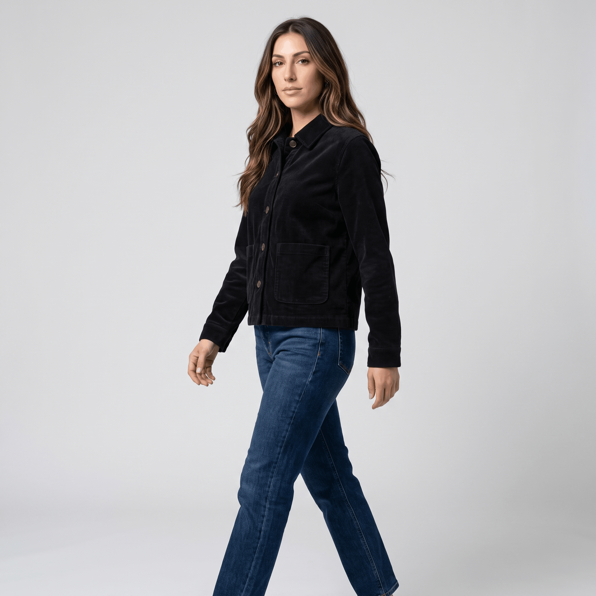 Black cotton corduroy chore jacket with a boxy fit, button-front, and deep patch pockets worn with blue jeans.