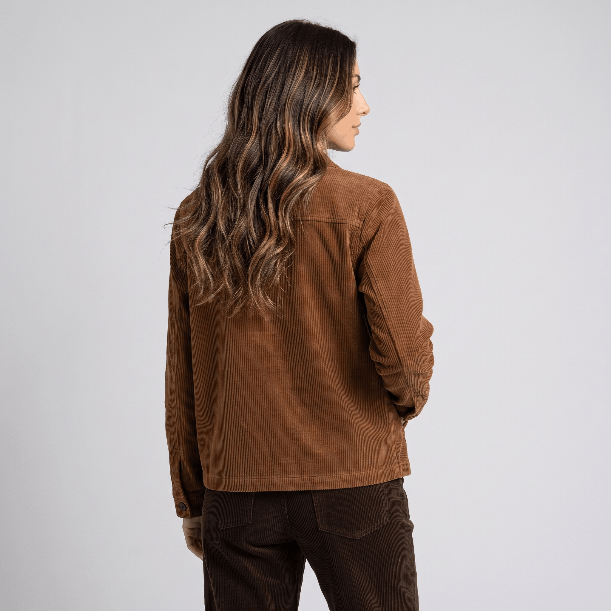 Brown wide-wale cotton corduroy chore jacket with a boxy fit and straight hem, worn over dark corduroy trousers.