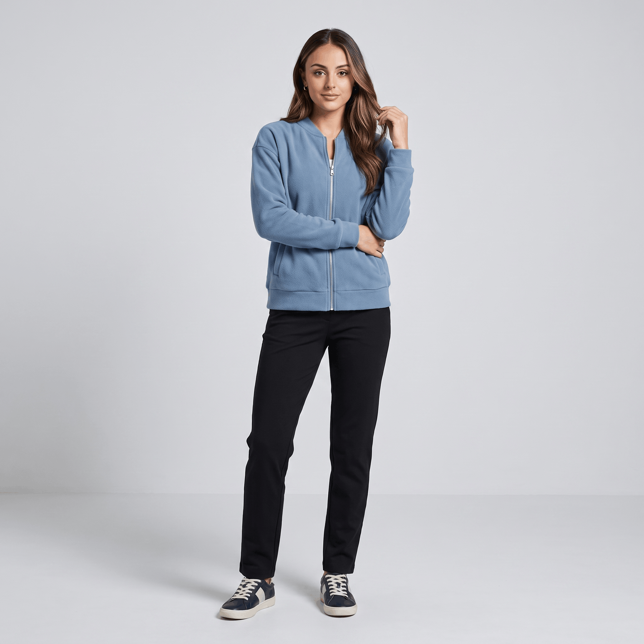 Female model wearing the light blue jacket with dark trousers and white sneakers.