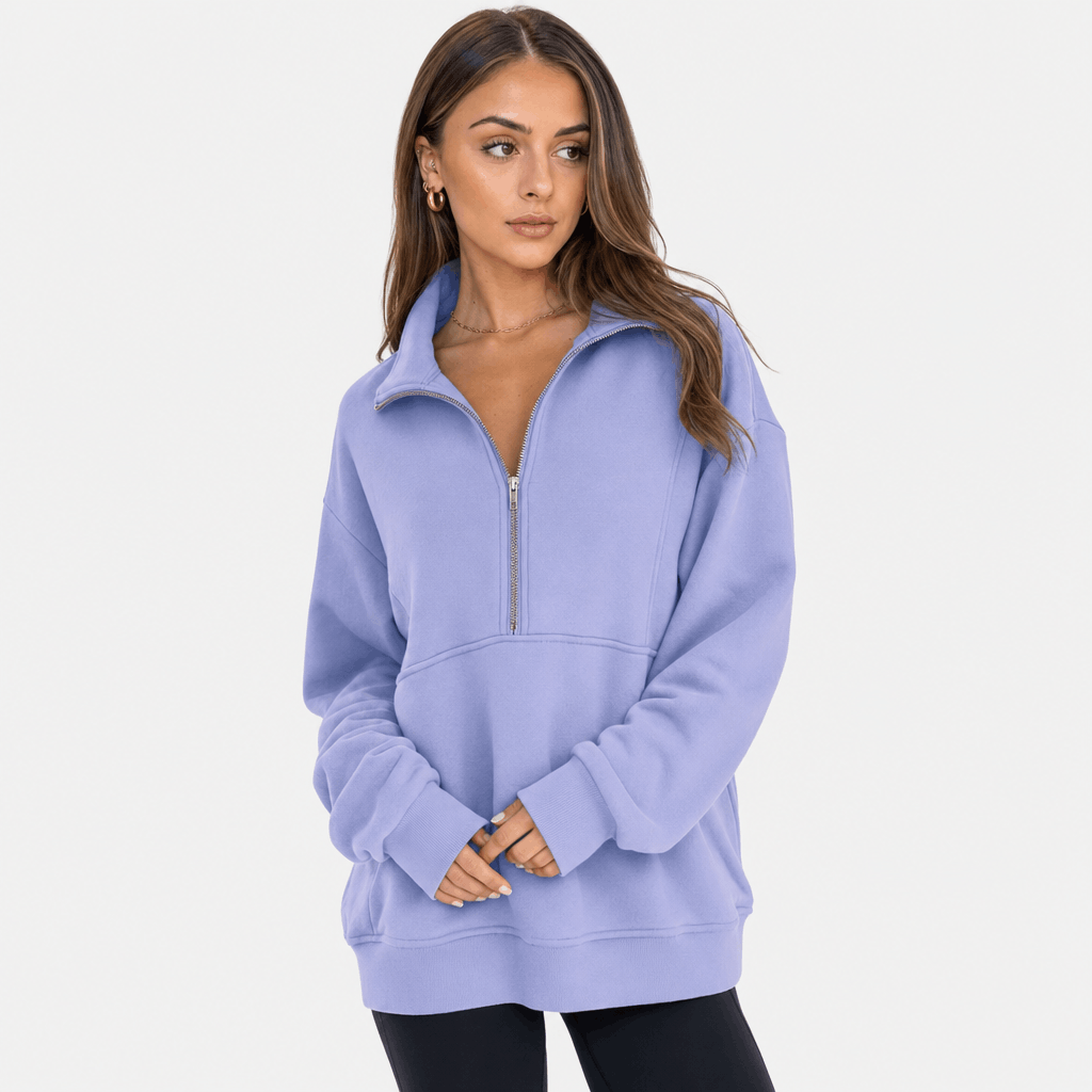 Female model wearing a light purple quarter-zip pullover with black trousers.