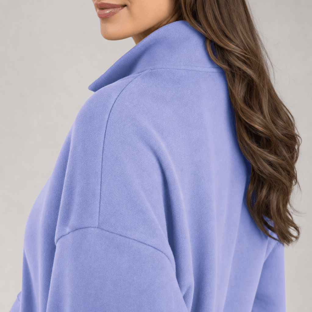 Back and side close-up of the light purple quarter-zip pullover, highlighting the raised collar and relaxed shoulder fit.