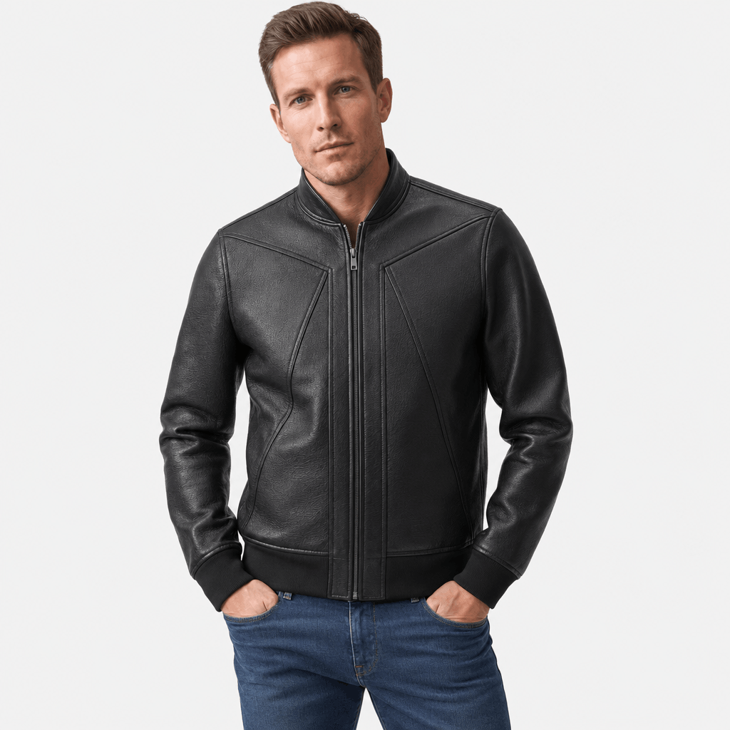 Male model wearing a black leather-style zip-up jacket with a stand collar, seam detailing, and zippered pockets, paired with blue jeans.
