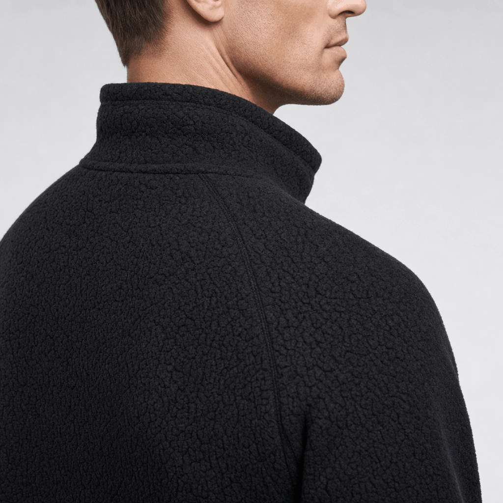 Close-up back view of the dark charcoal fleece jacket, highlighting the raised collar and textured fabric.