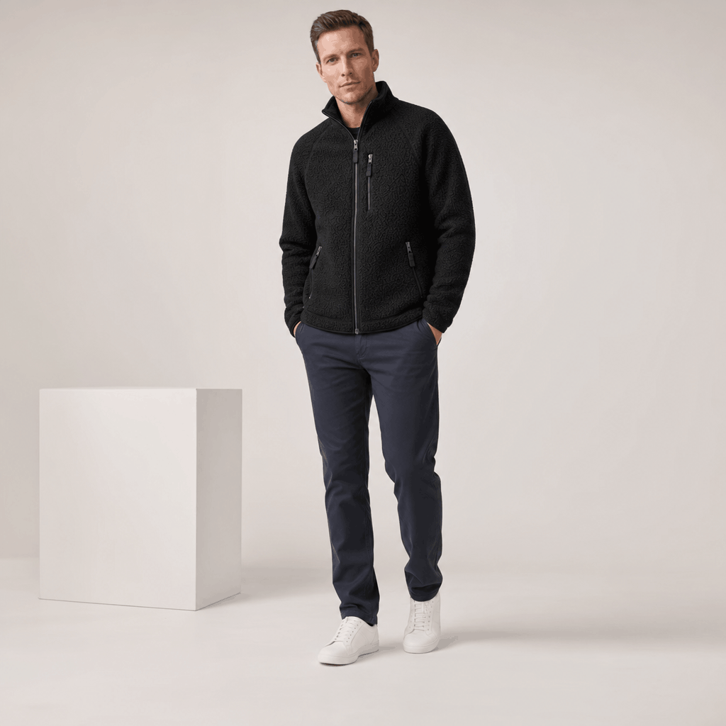 Male model wearing the black zip-up fleece jacket with dark jeans.