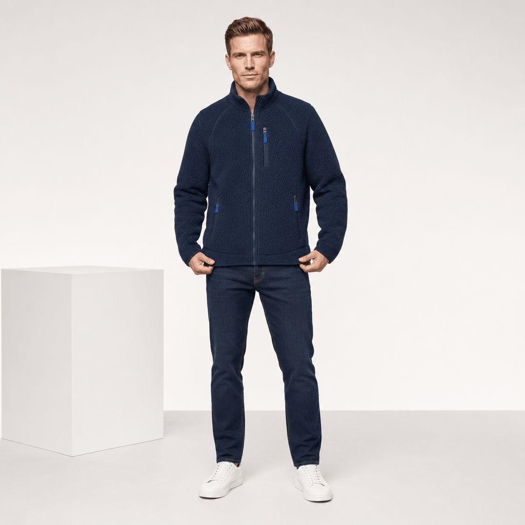 Full-body view of a male model wearing the navy blue fleece jacket with light-colored sneakers.