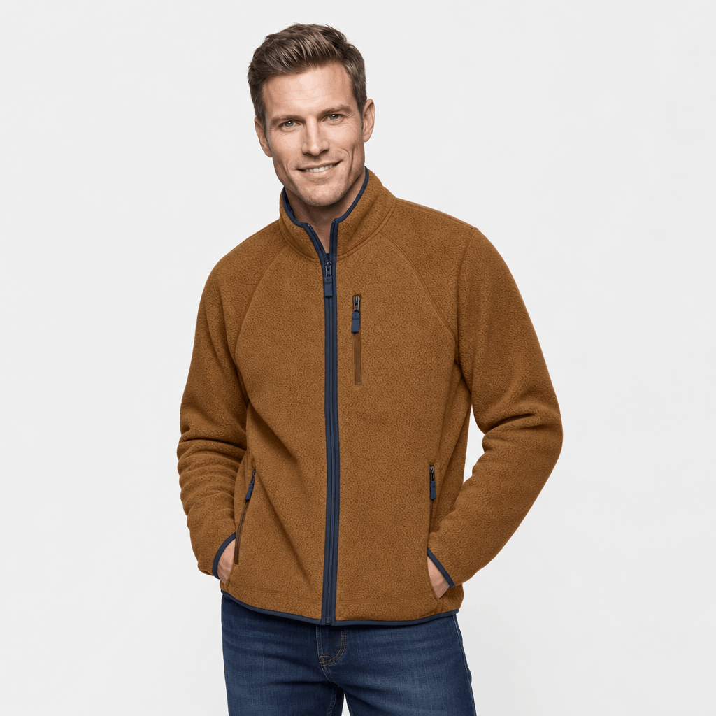 Male model wearing a brown fleece zip-up jacket with a high stand collar and contrasting zippered pockets.
